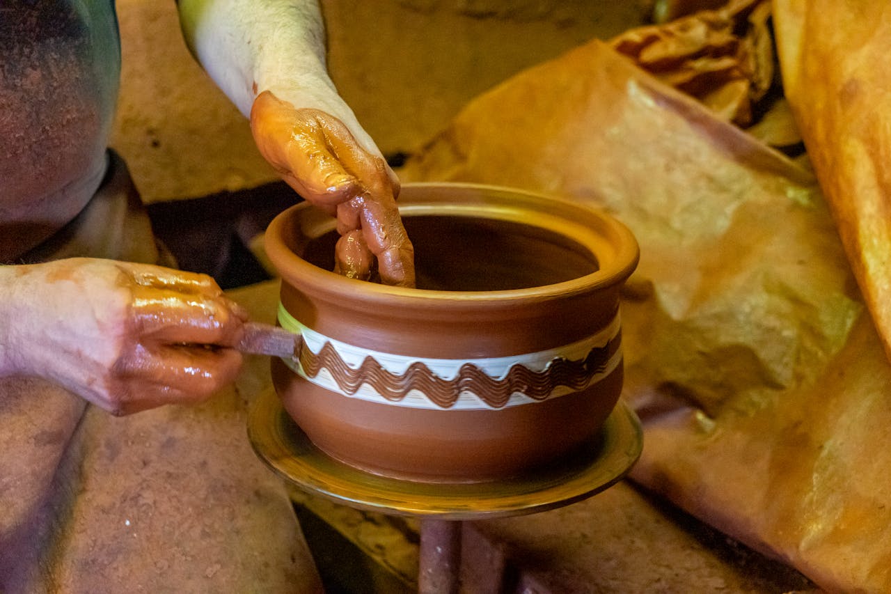 artisan-crafting-clay-pot-with-intricate-design-34259450
