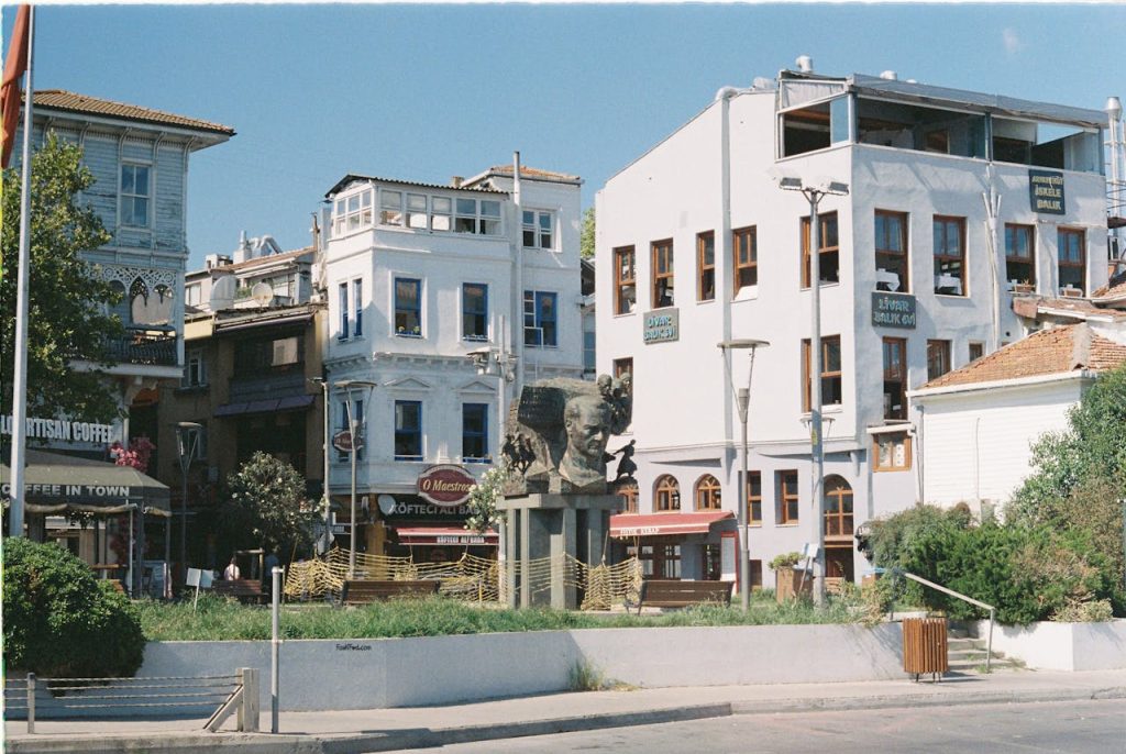 A quaint street scene showcasing historic buildings and a notable bust in a vibrant neighborhood.